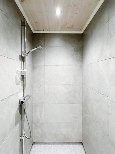 a shower stall with a shower head in a bathroom at Ystad Holiday Houses in Ystad