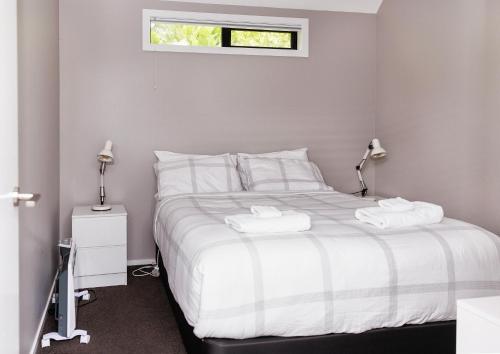 a bedroom with a white bed with two towels on it at Lake View Studio in Lake Tekapo