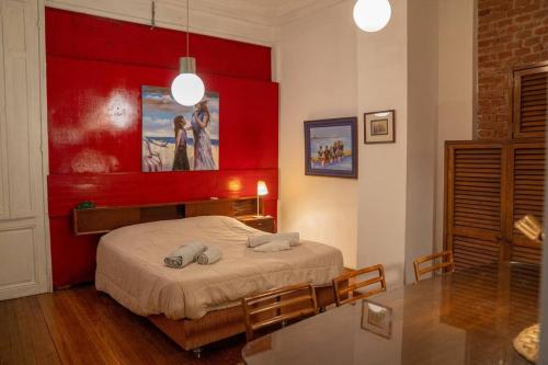1 dormitorio con 1 cama con pared roja en The Wall Montevideo [004] Loft in the Old Town en Montevideo