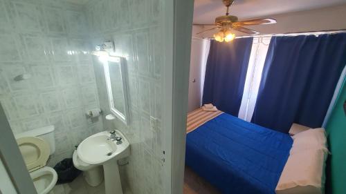 a bathroom with a bed and a toilet and a sink at Santa Clara in Necochea