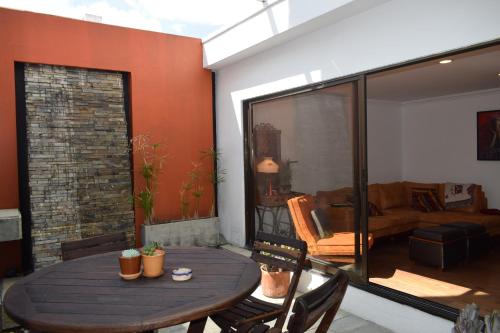 a room with a wooden table and a living room at Casa Pabón in Bogotá