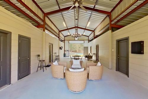 a screened porch with wicker chairs and a chandelier at The Barn in Arp