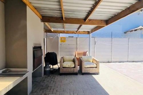 a covered patio with two chairs and a television at West Coast comfortable stays in Cape Town