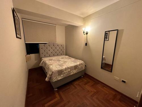 Lugar acogedor, céntrico:3H,WIFI في كوسكو: غرفة نوم صغيرة مع سرير ومرآة
