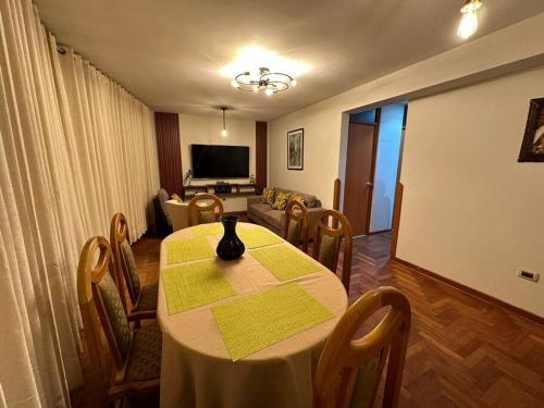 Lugar acogedor, céntrico:3H,WIFI في كوسكو: غرفة مع طاولة وكراسي وغرفة معيشة