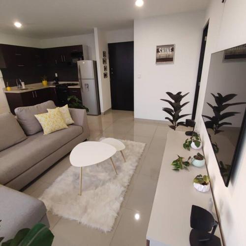 a living room with a couch and a table at Loft con Vista Panoramica Milenio lll Queretaro in Querétaro