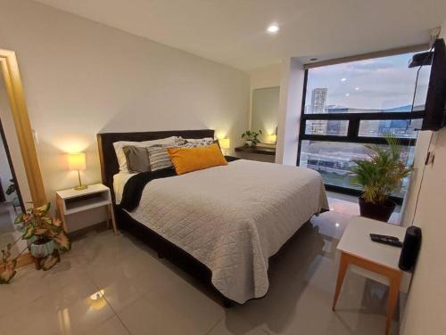 a bedroom with a bed and a large window at Loft con Vista Panoramica Milenio lll Queretaro in Querétaro
