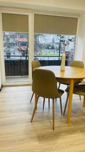 a dining room table with chairs and a vase on it at S&T&A&R apartamentai in Panevėžys