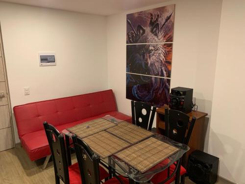 - une salle à manger avec une table et un canapé rouge dans l'établissement Alojamiento tipo LOFT completo en barrio Las Aguas, à Bogotá