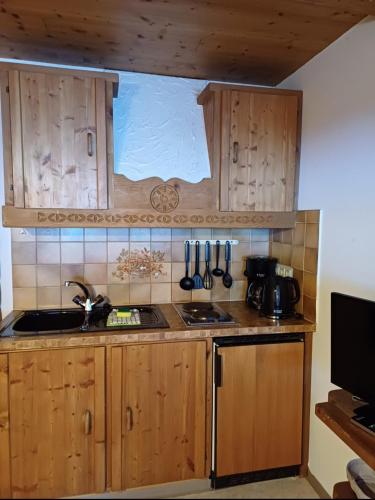 a kitchen with wooden cabinets and a sink at Landhaus Eberler in Mayrhofen