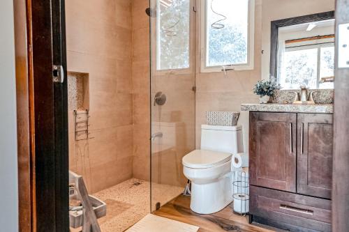 a bathroom with a toilet and a glass shower at Casa El Sueño in Brasilito