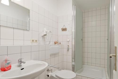 a bathroom with a sink and a toilet and a shower at Sanssouci Ferienwohnung 17 in Zinnowitz