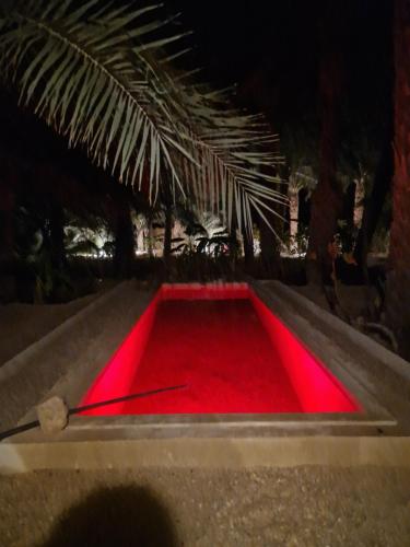 um tapete vermelho é iluminado com luzes vermelhas em Les Bungalows d'Armelle em Tozeur