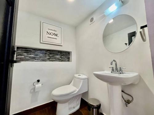 a bathroom with a toilet and a sink and a mirror at Tokio Loft Loft Moderno en Centro de Durango in Durango