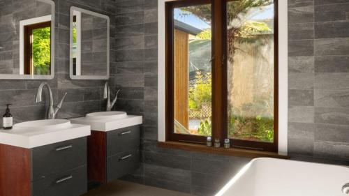 a bathroom with two sinks and a tub and a window at Sunset Haven in Nelson in Nelson