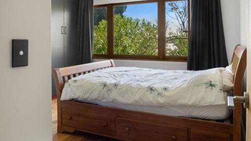 a bedroom with a bed in front of a window at Sunset Haven in Nelson in Nelson