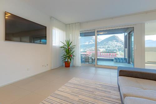 a living room with a couch and a large window at IMPERIAL of LUGANO 3 with a lake view behind the station and 10 min from the lake of Lugano in Lugano