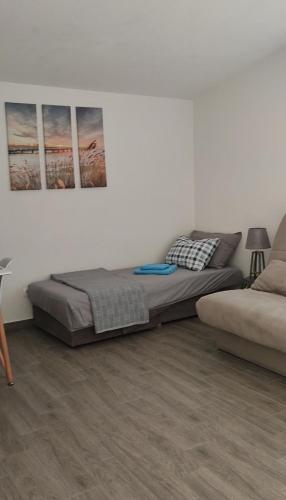 a bed in a room with two pictures on the wall at Sayohat Apartments in Dobra Voda