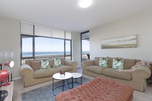 a living room with two couches and a table at Witsand 102 by HostAgents in Bloubergstrand