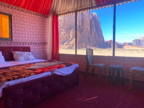 a bedroom with a bed and a view of the desert at Milky Way Nights Camp in Wadi Rum