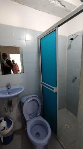 a bathroom with a toilet and a shower and a sink at Hostal La Casa De Mamá in Arboletes