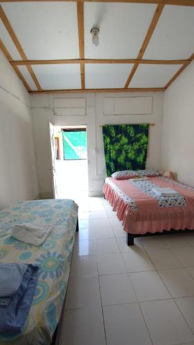 a bedroom with two beds in a room at Hostal La Casa De Mamá in Arboletes