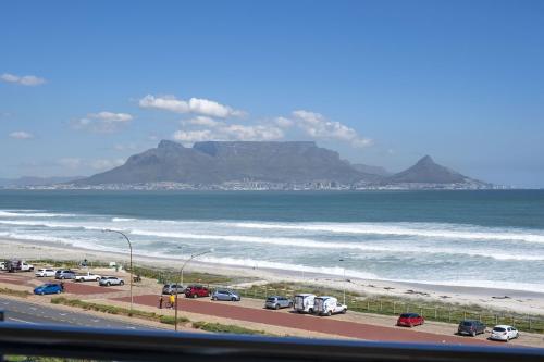 a view of a beach with a mountain in the background at Portico 405 by Host Agents in Bloubergstrand