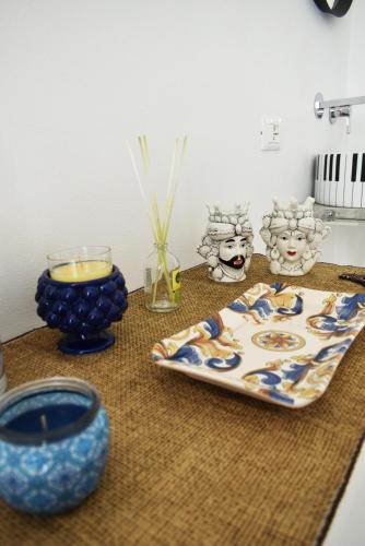 a table with blue vases and a plate with a candle at Casa Vacanze La Dimora di Santa Barbara in Petralia Soprana