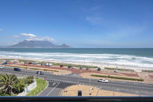 a view of a road with a beach and the ocean at Portico 405 by Host Agents in Bloubergstrand