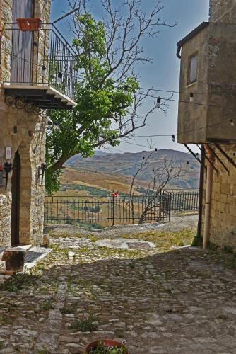 a stone building with a balcony and a fence at Casa Vacanze La Dimora di Santa Barbara in Petralia Soprana