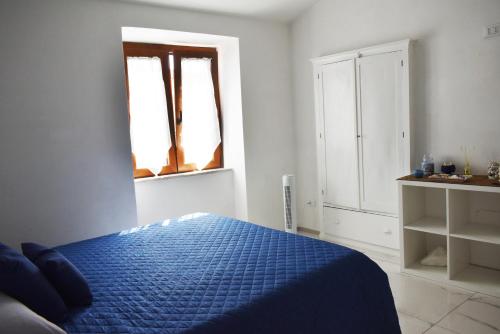 a bedroom with a blue bed and a window at Casa Vacanze La Dimora di Santa Barbara in Petralia Soprana