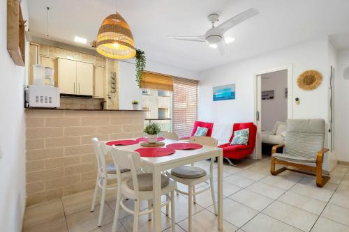 cocina y sala de estar con mesa y sillas en Hauzify I Apartament Llevant en Santa Susanna