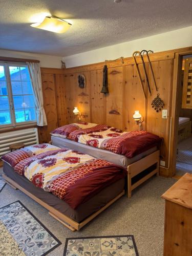 1 dormitorio con 1 cama en una habitación con paredes de madera en Flumserberg en Flumserberg