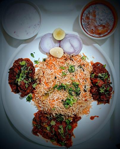 a plate of food with noodles and vegetables on a table at Menaka in Vijayawāda