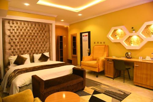 1 dormitorio con cama, escritorio y silla en Portland Resort Hotel, en Port Harcourt