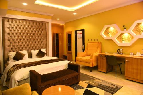 a bedroom with a bed and a desk and a chair at Portland Resort Hotel in Port Harcourt