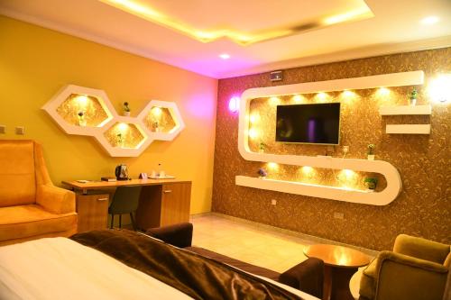 a hotel room with a bed and a tv and a chair at Portland Resort Hotel in Port Harcourt