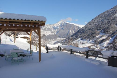 La Grange de Soulalex في أورسيير: شرفة مع طاولات وكراسي في الثلج