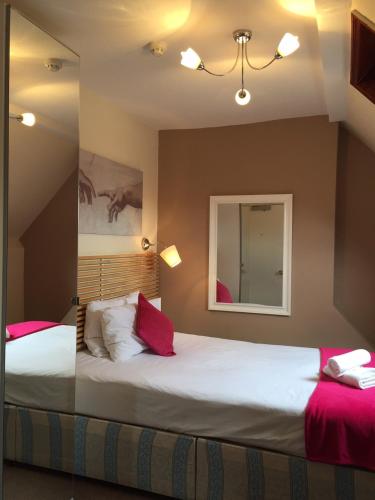 a bedroom with a large white bed with red pillows at Dockside Hotel in London