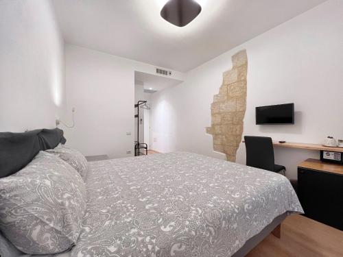 a bedroom with a bed and a desk and a television at Al Duomo di Cagliari in Cagliari