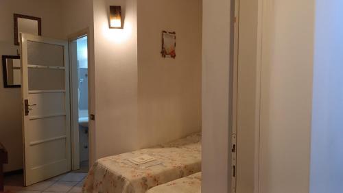 Habitación pequeña con cama y puerta abierta en Viandante, en Lecco