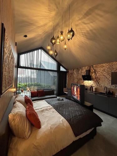 a bedroom with a large bed and a large window at te gast ByBreg in Apeldoorn