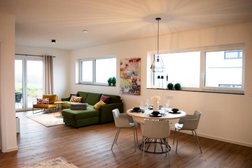 ein Wohnzimmer mit einem Tisch und einem grünen Sofa in der Unterkunft Hunsrück Lodge in Mittelstrimmig