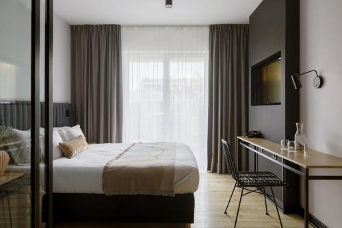 a hotel room with a bed and a desk at Hotel Saltic Resort & Spa Grzybowo in Kołobrzeg