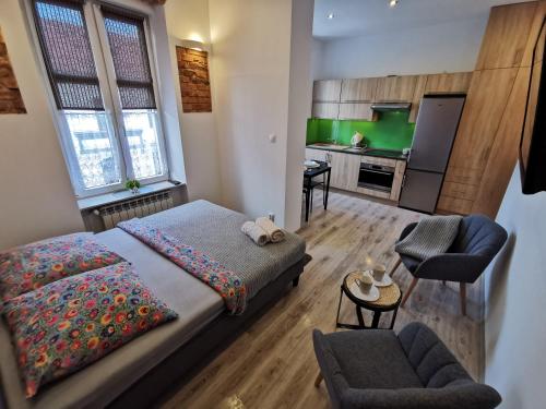 1 dormitorio pequeño con 1 cama y cocina en NADWIŚLAŃSKI APARTAMENT Kalwaryjska en Cracovia