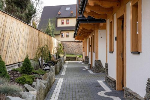 a walkway between two buildings in a garden at Osada LUX-HOUSE & SAUNA in Zakopane