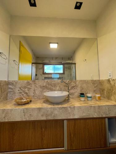 a bathroom counter with a sink and a mirror at Tronco do Ipê Hospedagem in Alto Paraíso de Goiás
