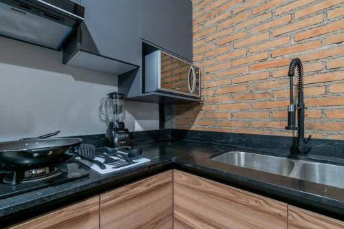 a kitchen with a sink and a brick wall at Depa Industrial Moderno #1 in Durango