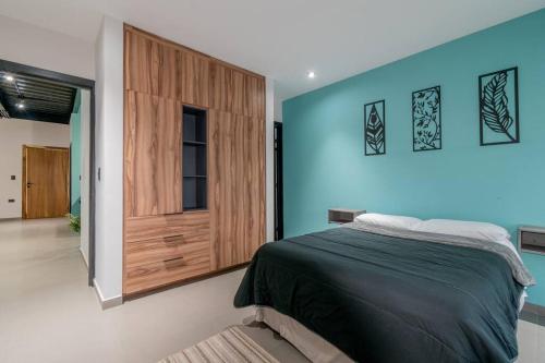 ein Schlafzimmer mit einem Bett und einer blauen Wand in der Unterkunft Depa Industrial Moderno #1 in Durango