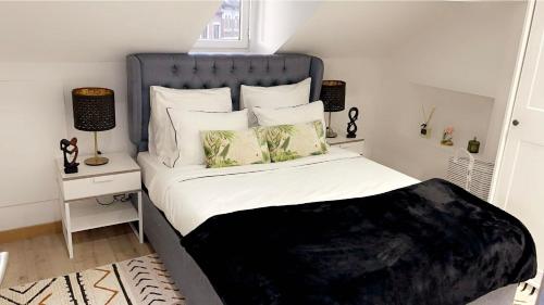 1 dormitorio con 1 cama con cabecero azul y almohadas en Calme, agréable et fonctionnel en Bruselas